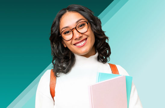Photo of a smiling woman with books in her arms.