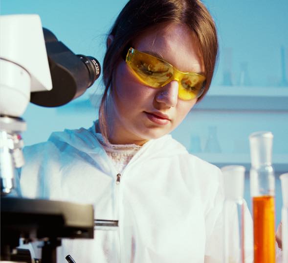 You lady in a lab setting mixing chemicals.