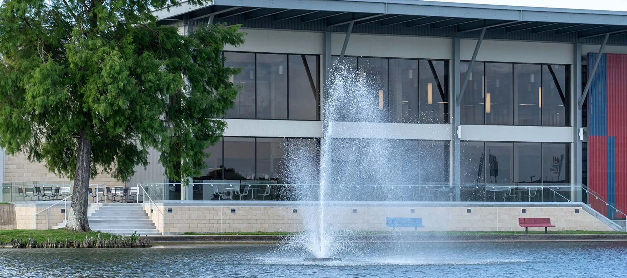 Student Center with lake and large fountain spraying water upwards.