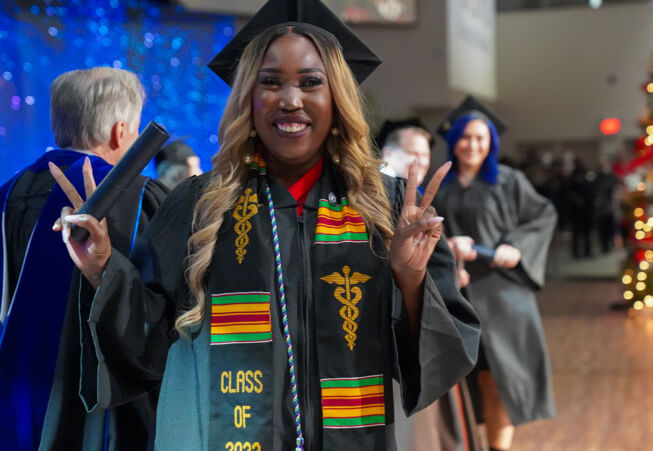 Student at graduation receiving her diploma