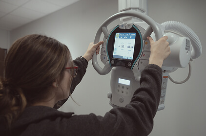 Rad Tech student using an X-Ray machine