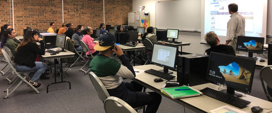 Group of students in a classroom watching an instructor presenting