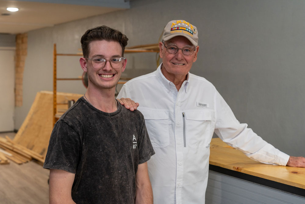 Austin Kidwell and grandfather Leslie Gilliam proudly stand in Austin’s liquidation shop