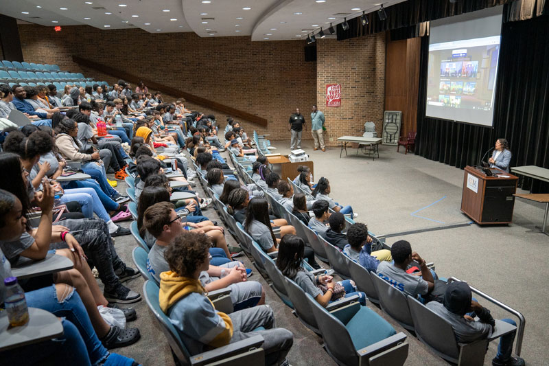Students at a presentation in large auditorium