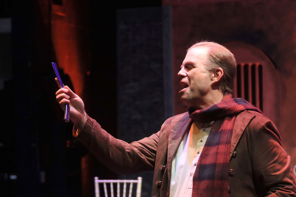 During a rehearsal, Sweeney Todd portrayed by Professor H. Russ Brown stares admirably to his straight razor. Photo Credit: Pin Lim/Forest Photography