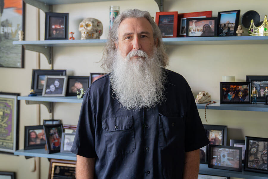 College of the Mainland Professor Bernie Smiley stands in his office surrounded by shelves filled with personal photos and mementos.