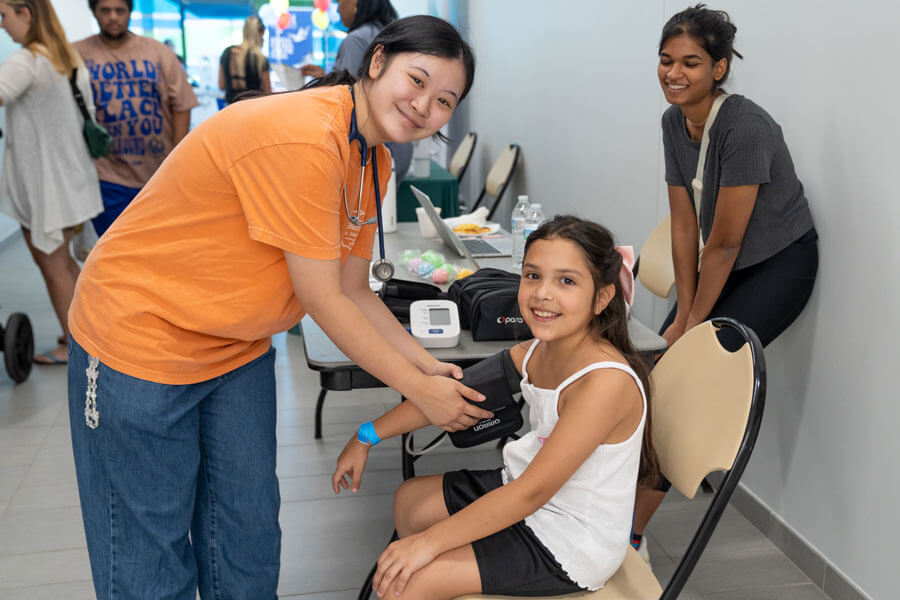 Young community member receives blood pressure reading by local health organization