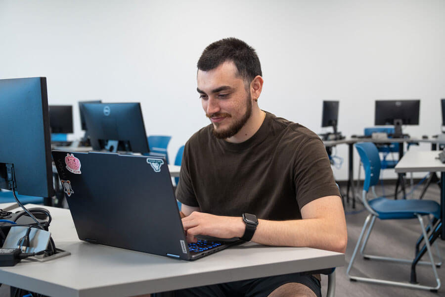 RPA Career Training Student Kevin Salazar Typing on his Laptop