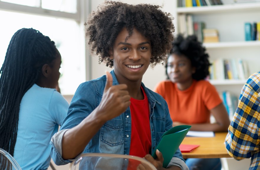 Smiling student giving a thumbs up.