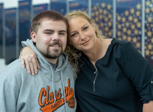 Portrait of a male promise student with his mom outside.