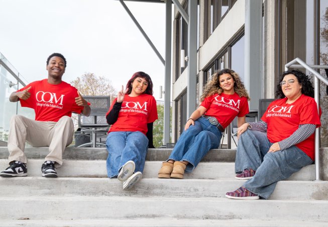 Group of students wearing red COM shirts by the pond.
